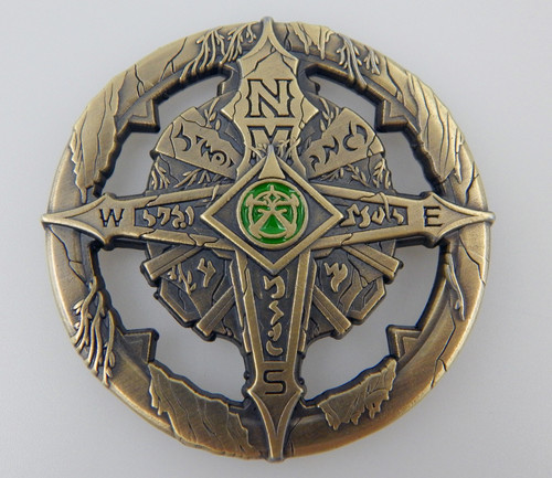 Pathfinder Compass shows a brass-colored compass featuring a four-pointed compass rose, at the middle of which is a green and gold symbol.