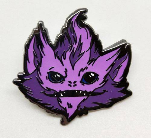 Starfinder Skittermander Pin (Purple) shows a dark and light purple furry creature’s face; the creature has pointed ears, black eyes, four nostrils, and a wide thin mouth with a few sharp teeth.