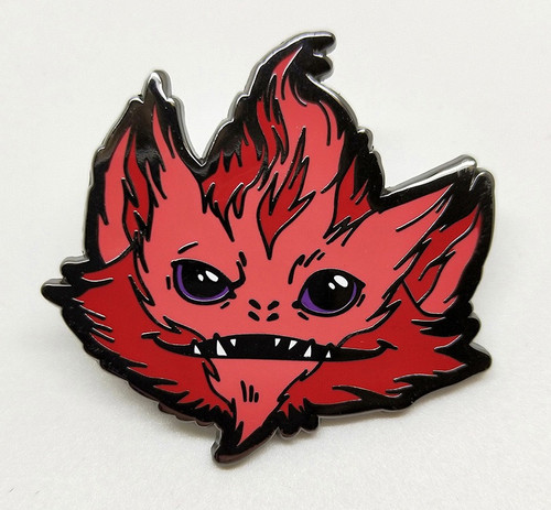 Starfinder Skittermander Pin (Red) shows a dark and light red furry creature’s face; the creature has pointed ears, black eyes, four nostrils, and a wide thin mouth with a few sharp teeth.