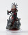 An image of the Midnight Lord, the Prince of Pain, Zon-Kuthon. Feet shrouded in shadows, his lean figure rises up in red, spiked, strapped, and studded leather armor. He bears spikes in his arms and head and blood covers him haphazardly. In his hand he carries a long, cruel chain. (Front View)