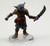 Standing as tall as a human, this muscular, gray-skinned creature peers about with tiny, observant eyes. It wears leather armor over a chain shirt. One hand holds out a crude sword ready to slash. (Front View)