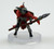 Ant gnolls are a smaller heritage of kholo, often distinguished by their proportionally larger ears. They are often scavengers dispatched to battlefields to gather the bones of their fallen allies. Rather than fight, many will choose to run from a confrontation. This ant gnoll wears a bright read cape and carries a shield on its back, both hands holding a spear ready to defend. (Front View)