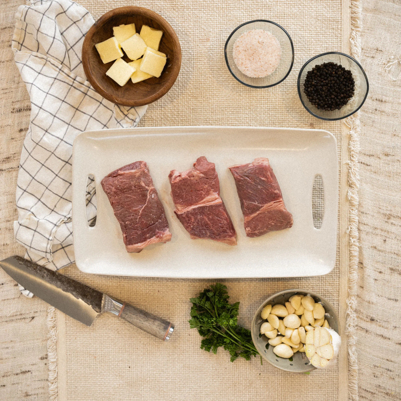 Hand cut top-sirloin steak with herbs on the side, locally sourced and recipe ready.