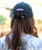 The back of a woman in a Black Hat with White Snolo