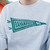 Close-up of the gray sweatshirt's teal pennant graphic, reading 'BAHAMA BUCK'S' and '90'.