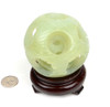 Natural serpentine jade puzzle ball with 5 layers and dragon-phoenix design on a wooden stand