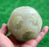 Close-up of jade puzzle ball showing abstract dragon and phoenix pattern