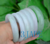 Different angle of jadeite bangles in hand under natural light.