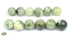 Group of 12 cloudy-pattern serpentine jade spheres on white background, with coin for size reference