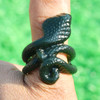 Single carved jade cobra thumb ring in natural light