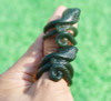 Group of carved nephrite jade cobra thumb rings in natural light