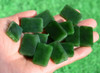 G026541B Hand holding Variant B premium green jade peace plaques in sunlight showing smooth texture.