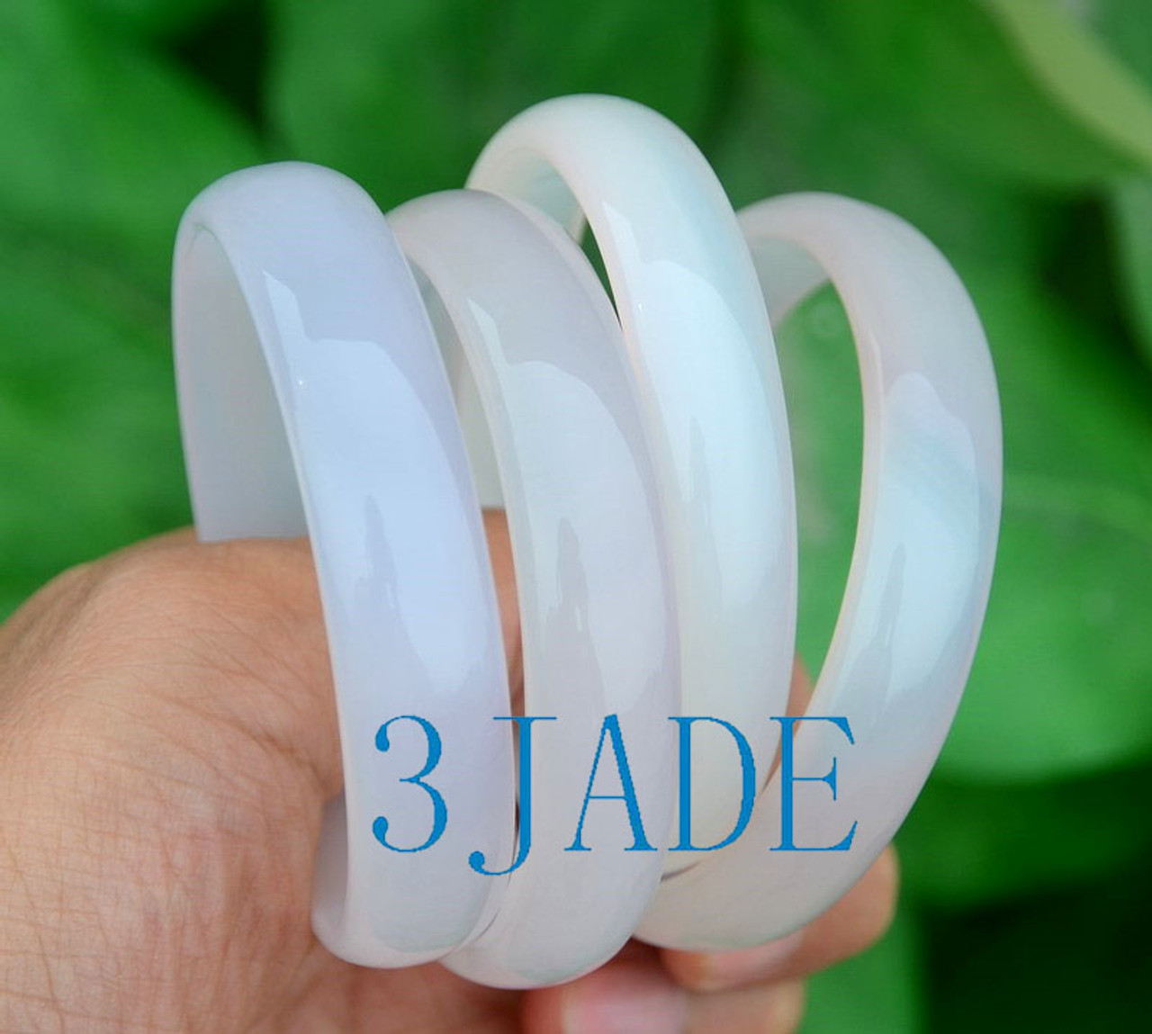 Lot 3 agate bangles from another angle in hand under natural light.