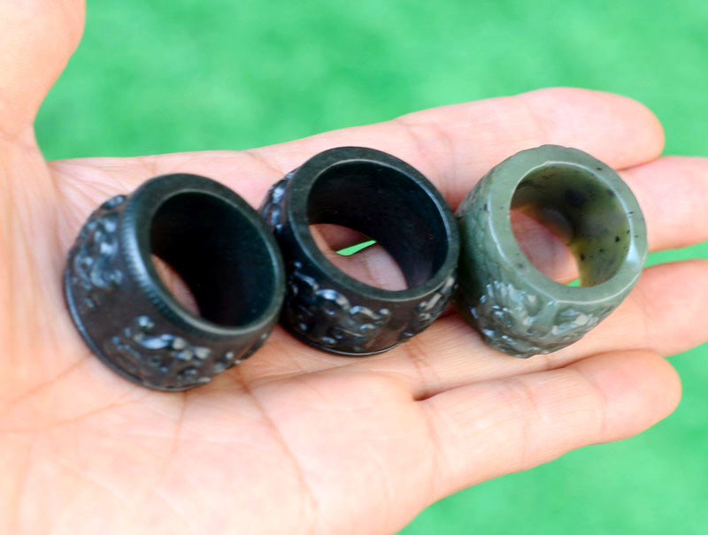 Carved nephrite jade thumb rings with beast and dragon motifs, alternate angle