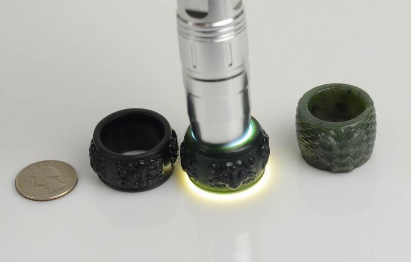 Nephrite jade thumb rings showing translucency under strong flashlight