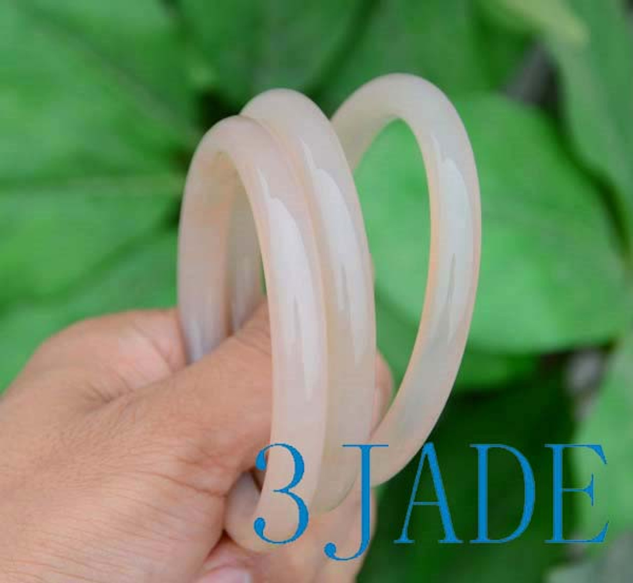 Hand holding agate bangles, showcasing smooth finish and light weight