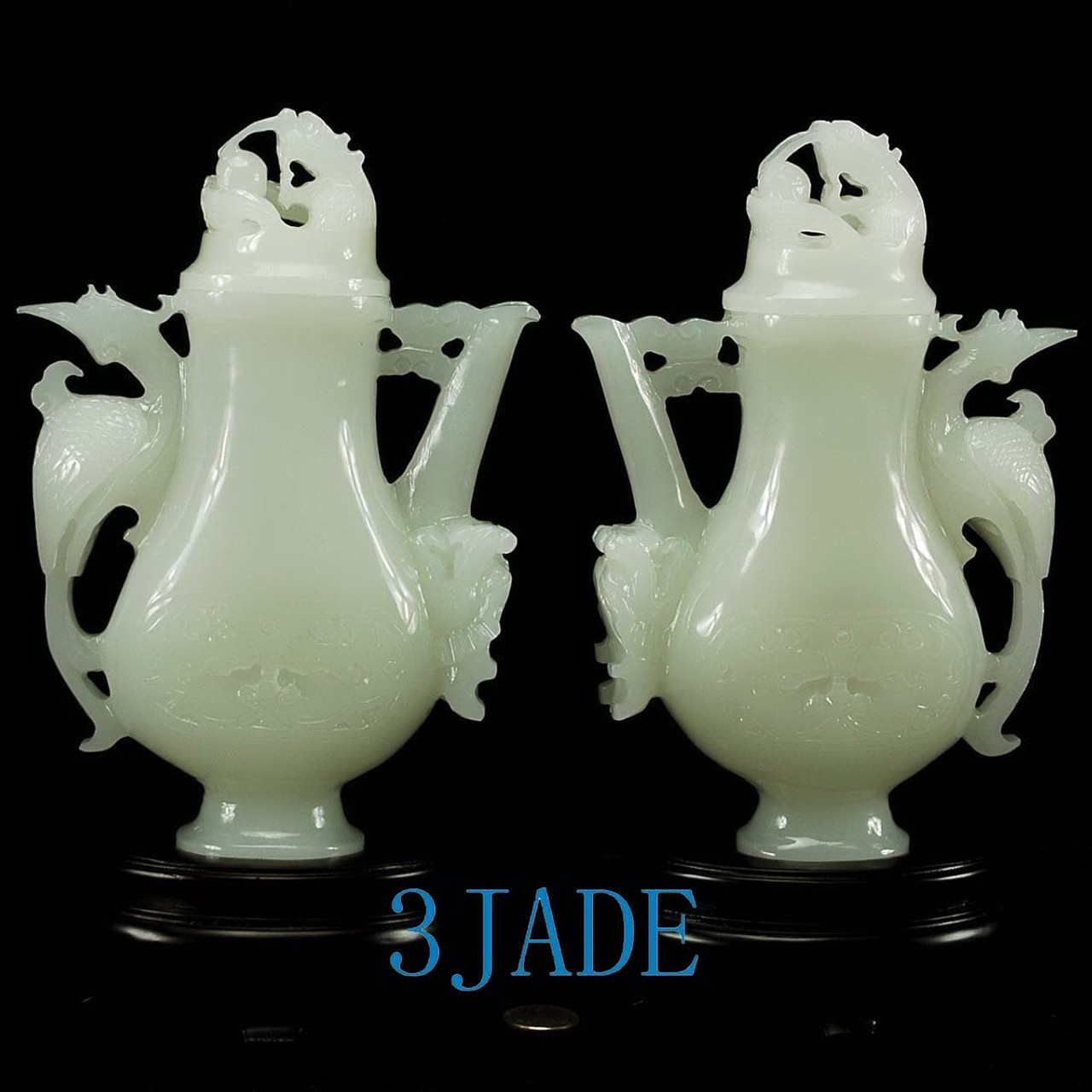 Two vases displayed together under lighting, with their wooden bases.