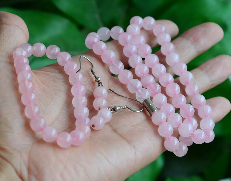 Rose quartz necklace, bracelet and earrings, showing beads in natural lighting.