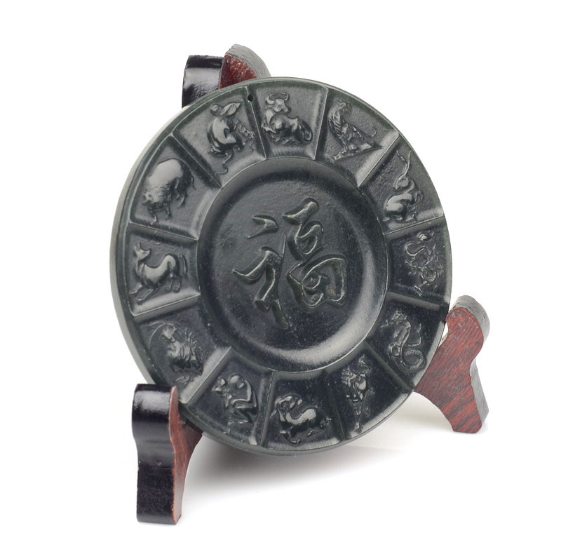 Side view of zodiac jade plaque on wooden stand
