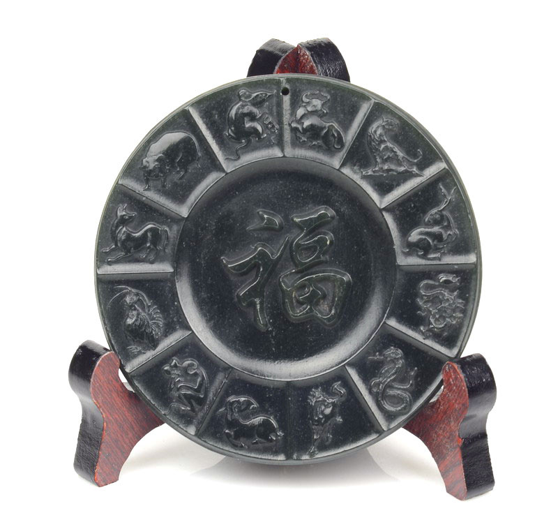 Nephrite jade zodiac plate with “Fu” character on stand, studio lighting