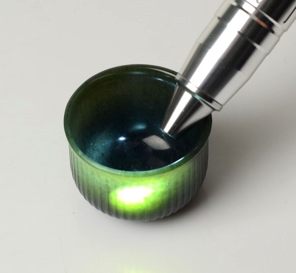 Nephrite jade cup under strong flashlight showing translucency and jade structure