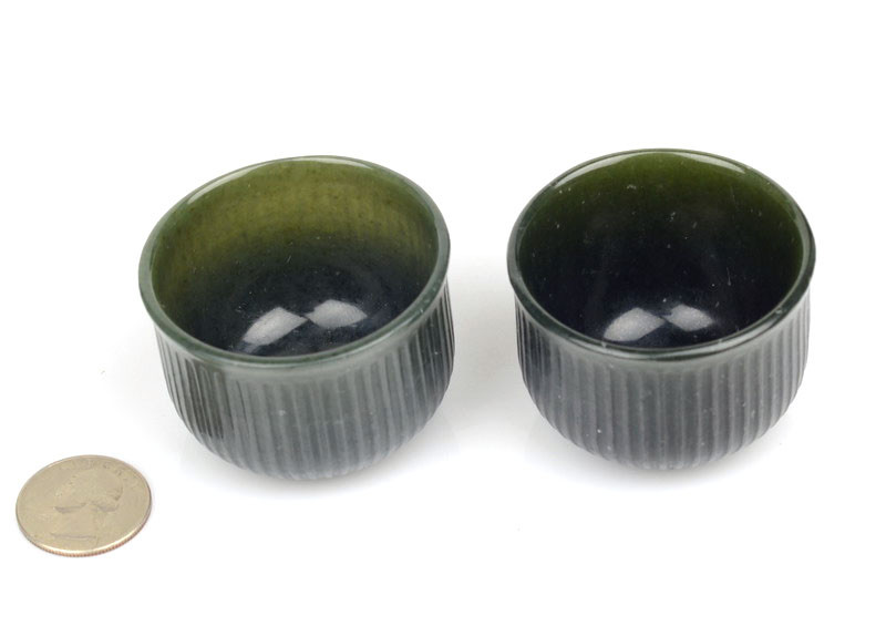 Ribbed nephrite jade tea cups at a slight angle under studio lighting