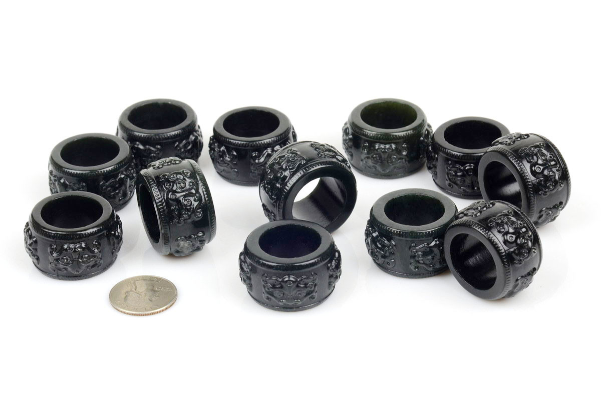 Carved nephrite jade thumb rings with beast head motif under studio lighting