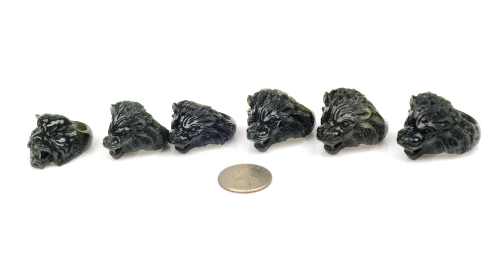 Group of carved nephrite jade beast-head thumb rings under studio lighting