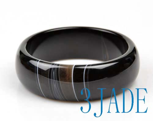 Collection of black onyx bangle bracelets with polished finish.