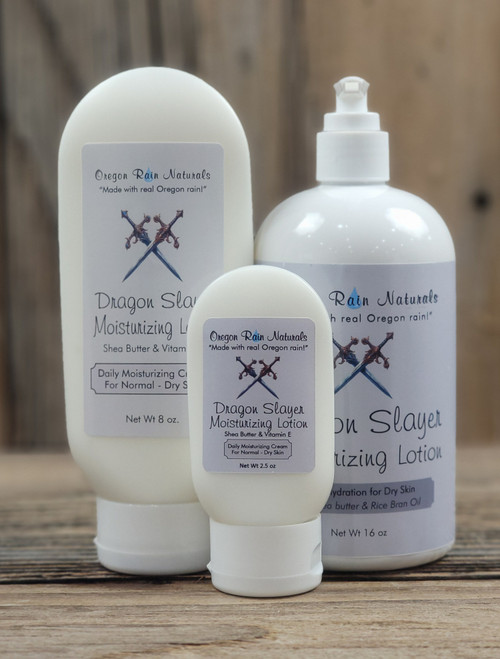 Dragon Slayer Moisturizing Lotion in three sizes—2.5 oz, 8 oz, and 16 oz bottles displayed on a wooden background.