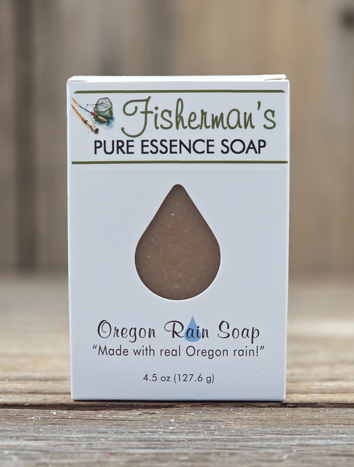 Boxed Fisherman’s Pure Essence Handmade Soap by Oregon Rain Naturals, featuring a teardrop cutout revealing the bar inside. Packaging highlights “Made with real Oregon rain!” and includes fishing gear artwork. Net weight: 4.5 oz.