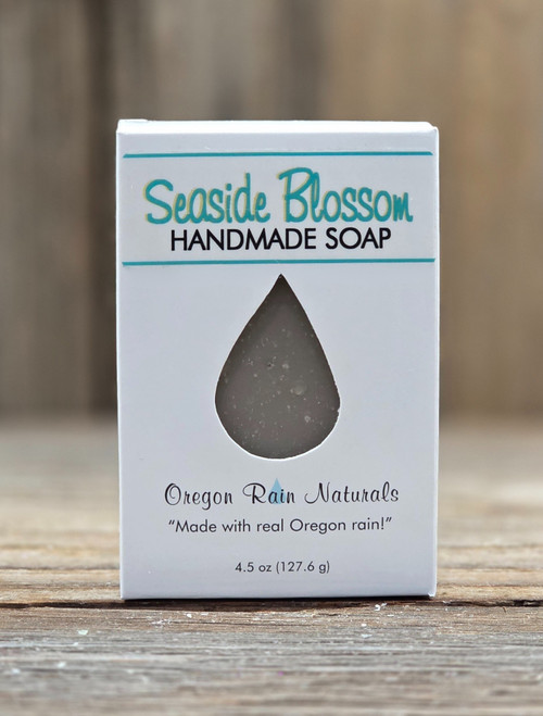 Boxed Seaside Blossom Handmade 4.5 oz Soap featuring an open raindrop to view the color of the soap and to smell the wonderful essence of a coastal breeze – where airy florals mingle with ocean mist, softened by green leaves and a warm whisper of amber and musk.