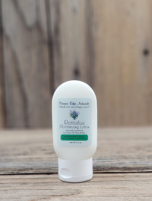 2.5 oz bottle of Revitalize Moisturizing Lotion on a wooden surface, featuring mint and herbal imagery on the label.