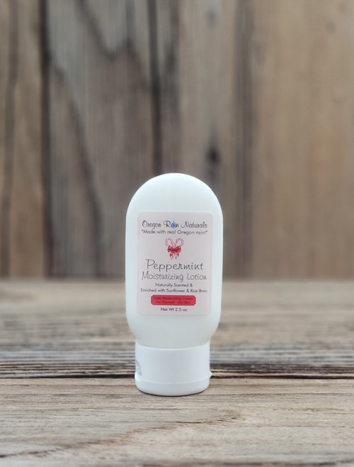 2.5 oz bottle of Peppermint Moisturizing Lotion on a wooden surface, featuring peppermint imagery on the label.