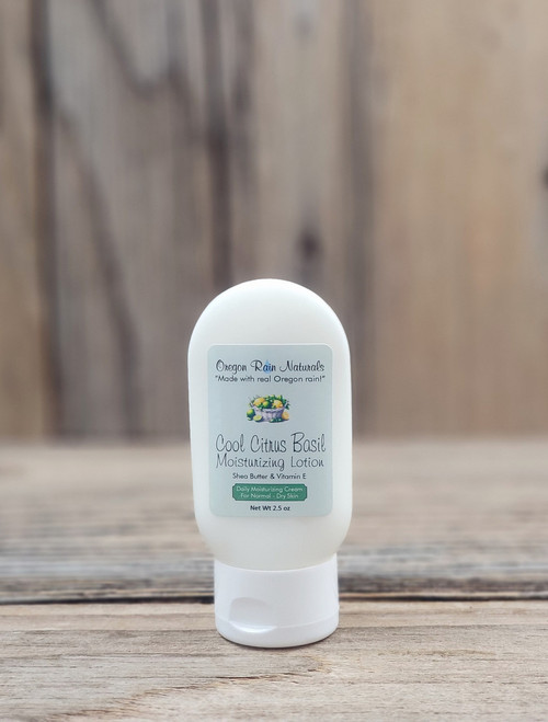 2.5 oz bottle of Cool Citrus Basil Moisturizing Lotion on a wooden surface, featuring citrus and basil imagery on the label.
