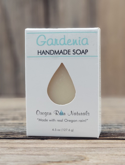 Boxed Gardenia Handmade Soap by Oregon Rain Soap, featuring a teardrop cutout revealing the bar inside. Packaging highlights “Made with real Oregon rain!” Net weight: 4.5 oz