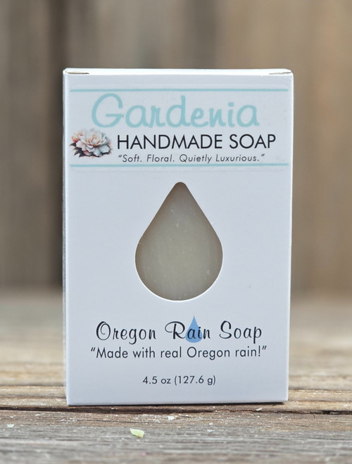 Boxed Gardenia Handmade Soap by Oregon Rain Soap, featuring a teardrop cutout revealing the bar inside. Packaging highlights “Made with real Oregon rain!” Net weight: 4.5 oz
