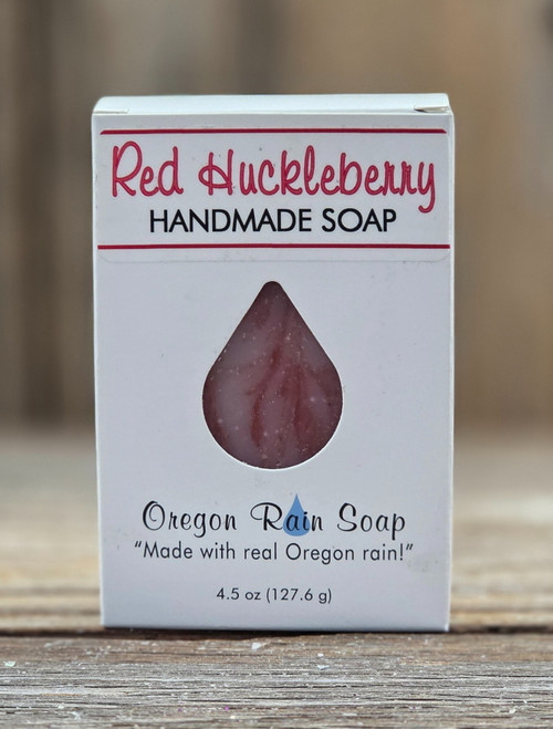 White boxed Red Huckleberry Handmade 4.5 oz Bar Soap with a raindrop cutout for viewing the red swirls of the soap bar and smell the sweet smelling soap.
