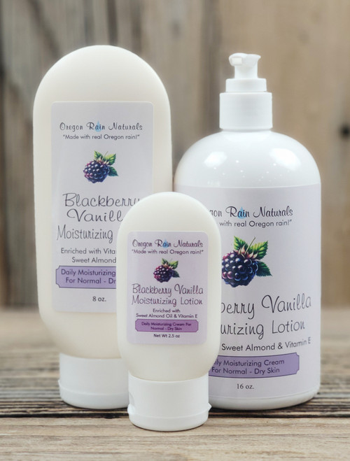 Blackberry Vanilla Moisturizing Lotion in three sizes—2.5 oz, 8 oz, and 16 oz bottles displayed on a wooden background.