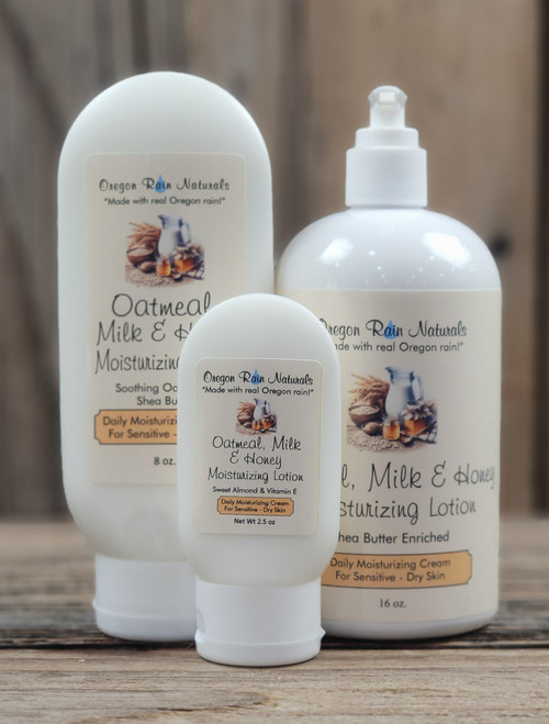 atmeal, Milk & Honey Moisturizing Lotion displayed in three sizes—2.5 oz, 8 oz, and 16 oz bottles with cream-colored labels on a wooden background.
