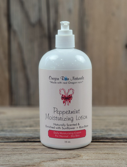 16 oz pump bottle of Peppermint Moisturizing Lotion enriched with shea butter, displayed on a wooden surface.