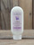 8 oz bottle of Lilac Moisturizing Lotion with lilac flower graphics on the label, shown on a wooden background.