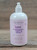 16 oz pump bottle of Lilac Moisturizing Lotion enriched with shea butter, displayed on a wooden surface.