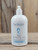 16 oz pump bottle of Rain Moisturizing Lotion enriched with shea butter, displayed on a wooden surface.