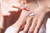 A small amount of creamy white moisturizing lotion on the back of a hand against a white background.
