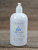 16 oz pump bottle of Rain Moisturizing Lotion enriched with shea butter, displayed on a wooden surface.