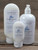 Rain Moisturizing Lotion in three sizes—2.5 oz, 8 oz, and 16 oz bottles displayed on a wooden background.