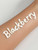 The word "Blackberry" written on a forearm with our thick, creamy lotion