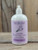 16 oz pump bottle of Lavender Moisturizing Lotion enriched with shea butter, displayed on a wooden surface.