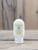 2.5 oz bottle of Jasmine Moisturizing Lotion on a wooden surface, featuring jasmine floral imagery on the label.